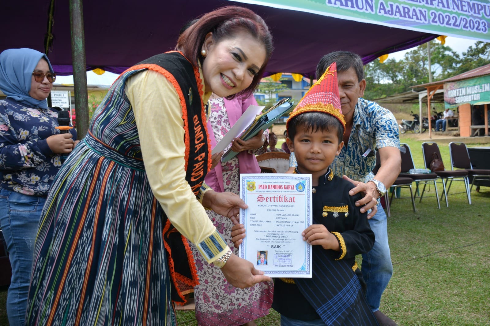 Bunda PAUD Romy Mariani SImarmata (kiri) Serahkan Sertifikat kepada siswa.(foto/isrimewa)