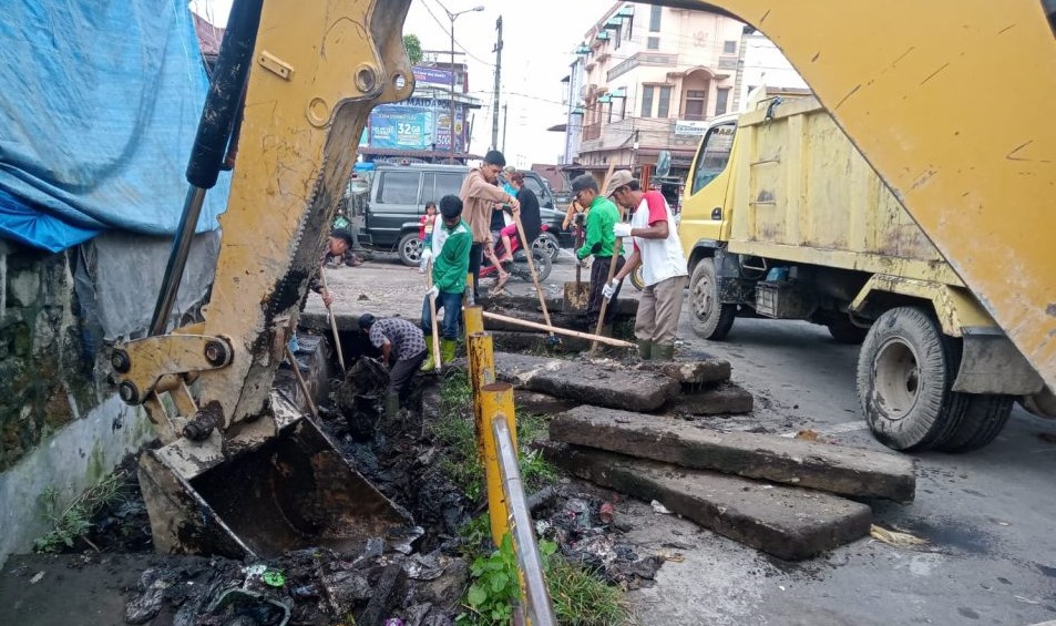 Alat berat dan petugas lakukan pembersihan parit di Pasar Sidikalang.(foto/istimewa)