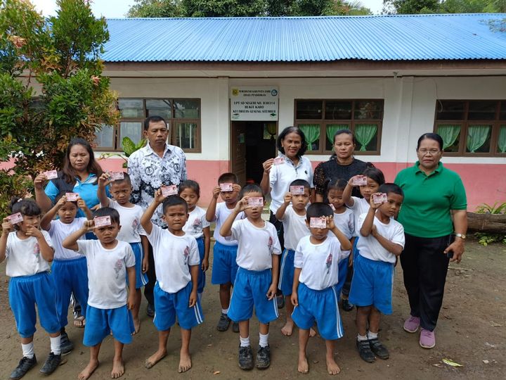 Tampak Kepala Sekolah SD Negeri 030314 Bukit Karo Nurdiana Boang Manalu bersama beberapa guru kelas membagikan KIA para siswa-siswi.(foto/ist)