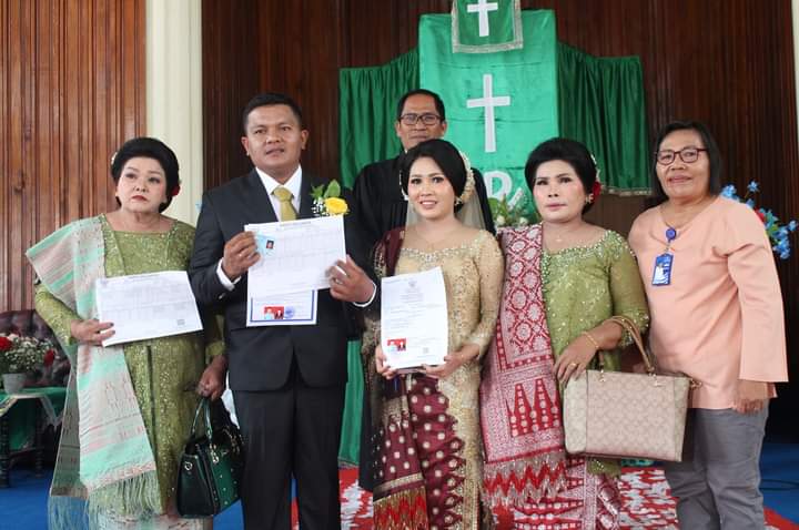 Pejabat fungsional Disdukcatpil Dairi Nurdingse Simbolon menyerahkan akta perkawinan suami isteri, Kartu Keluarga dan KTP-el suami.(foto/ist)