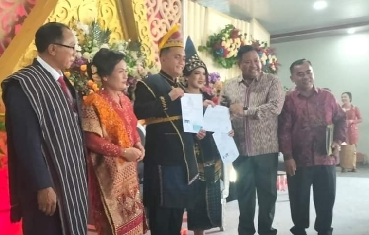Bupati Dairi Eddy Berutu serahkan akta nikah pengantin baru di Kecamatan Sumbul.(foto/ist)