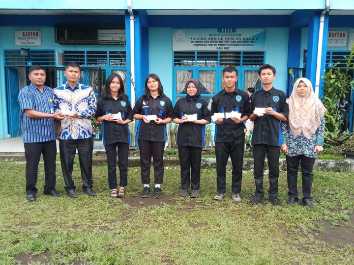 Tampak wakil kepala sekolah SMK Swasta Maranatha Sidikalang Rommel Walter Sirait, S.Pd membagikan KTP-el dan KIA kepada para pelajar.(foto/ist)