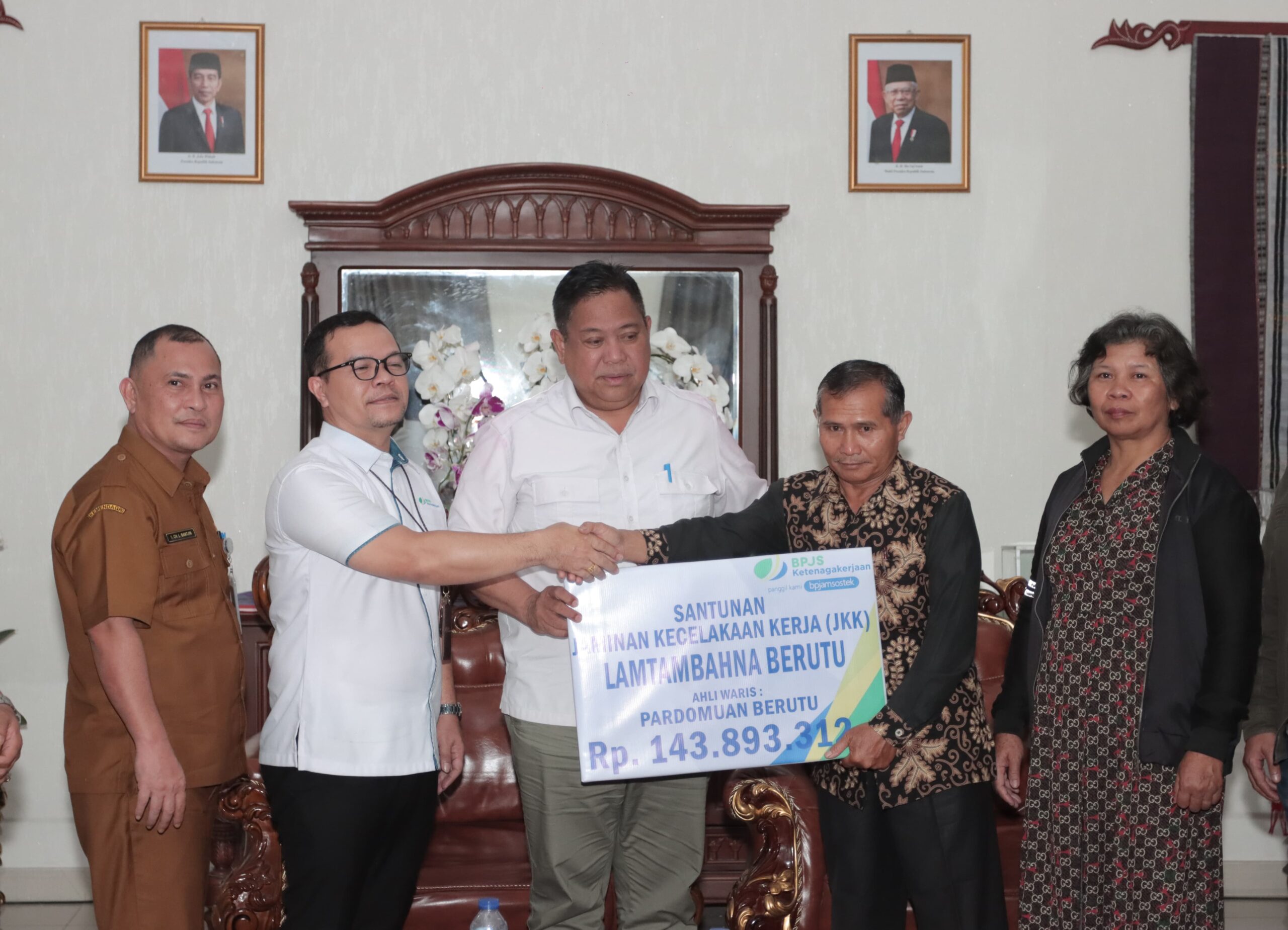 Bupati Eddy Berutu (tengah) saksikan penyerahan santunan dari BPJS Ketenagakerjaan bagi ahli waris Lamtambahna Berutu. (foto/ist)