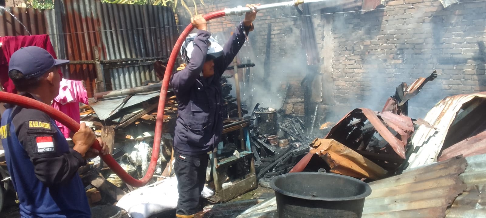 Petugas UPT Damkar Kabupaten Dairi sedang berusaha memadamkan api yang melahap rumah di Batang Beruh, (10/3/2024). (foto/ist)
