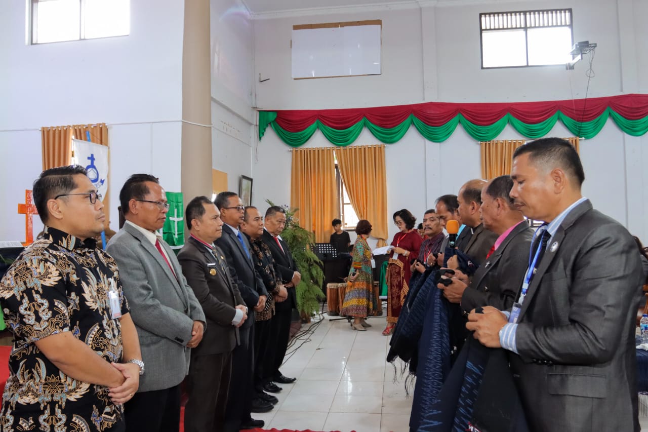 Penyematan cinderamata Oles Kepada Pj Bupati Dairi (ketiga dari kiri) pada Sinode Sinunu XI GKPPD. (foto/ist)