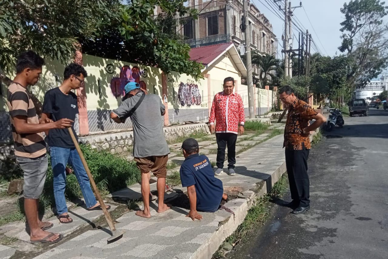 Pembersihan drainase depan SMP negeri 2, Kelurahan Bukit Sofa, Kecamatan Siantar Sitalasari.(Foto/Hegi)