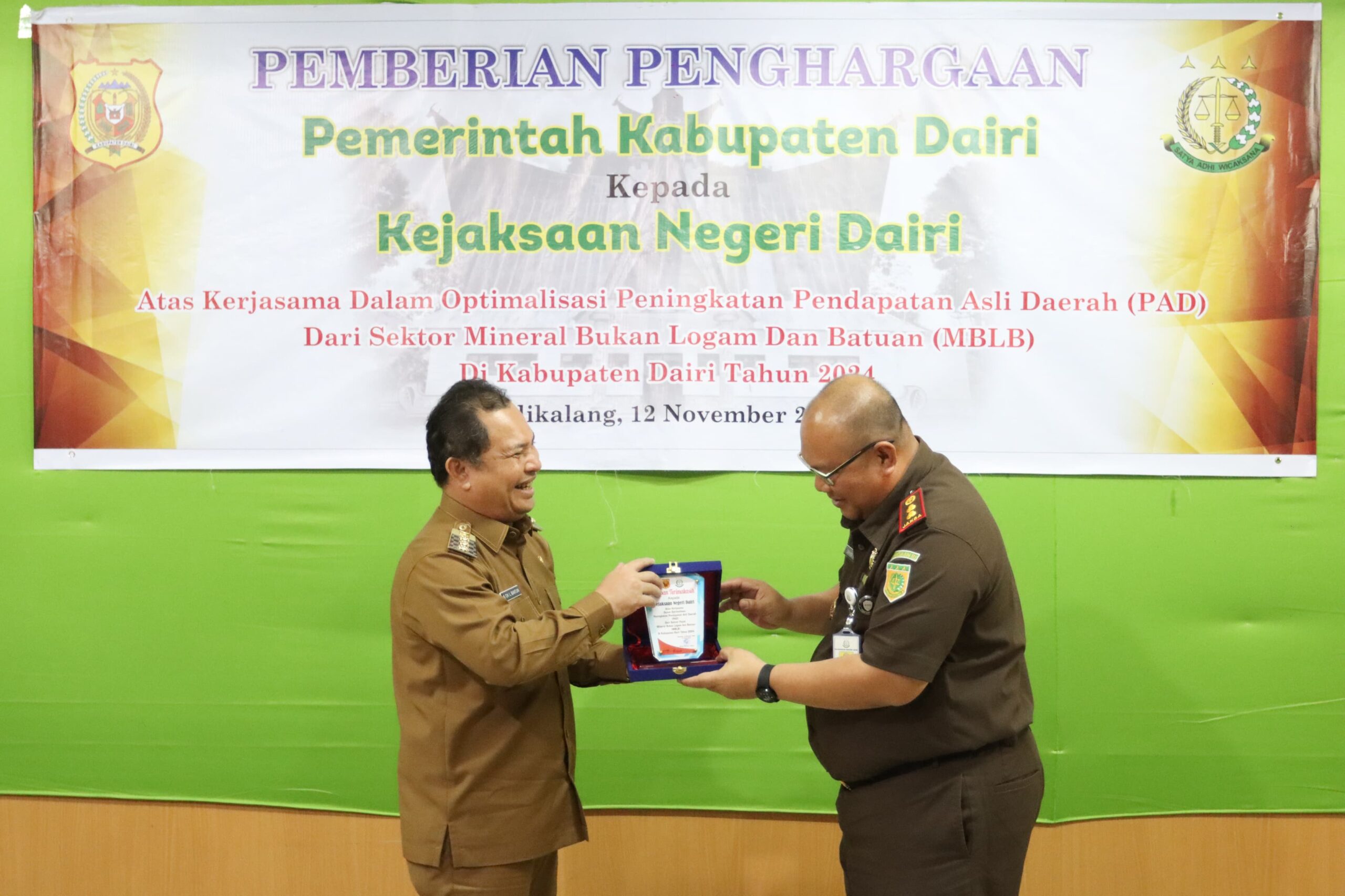 Pj Bupati Dairi, Charles Bantjin (kiri) menyerhakan Plakat ke Kajari Dairi, Cahyadi Sabri SH.(foto/ist)